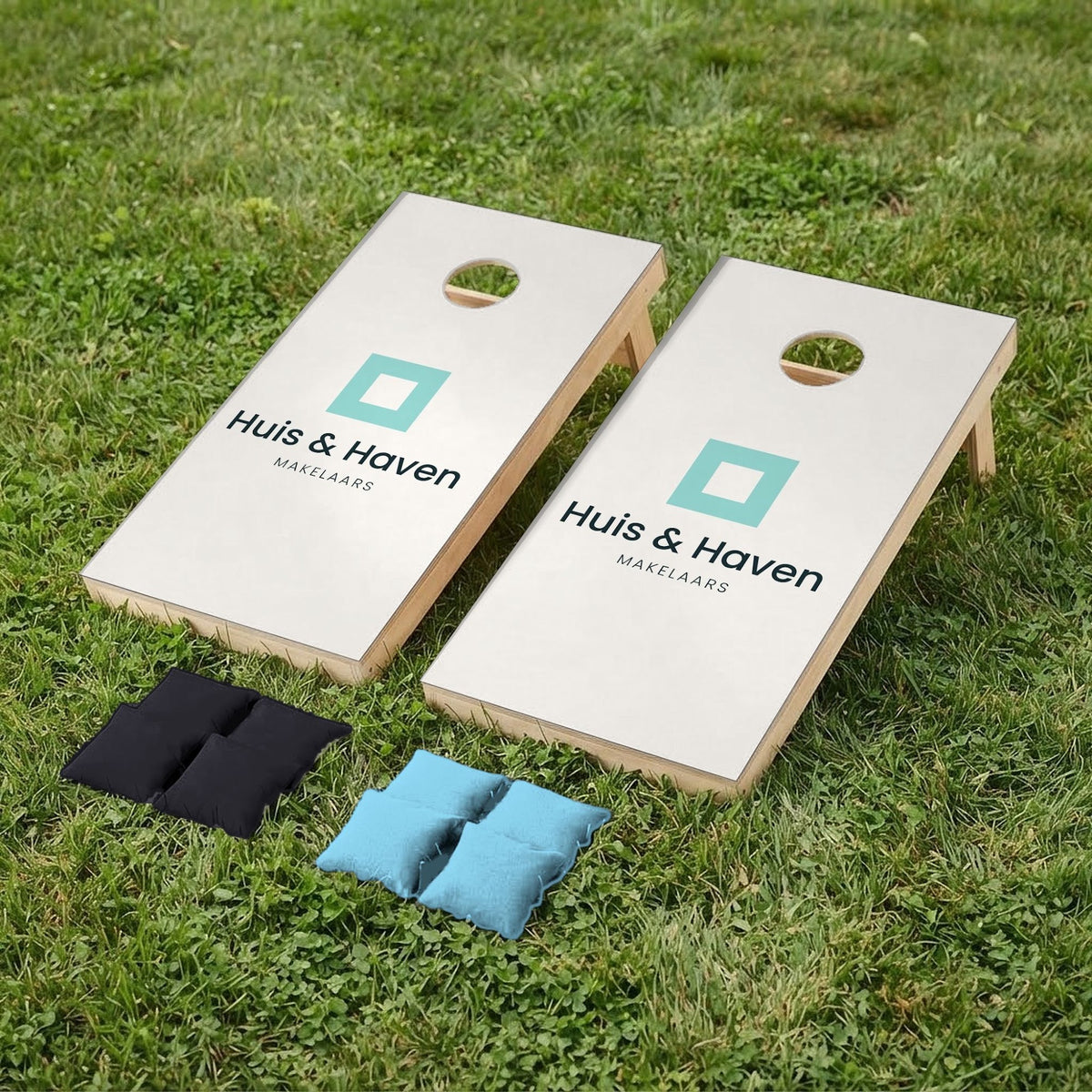 Cornholeset bedrijfslogo Huis & Haven op gras